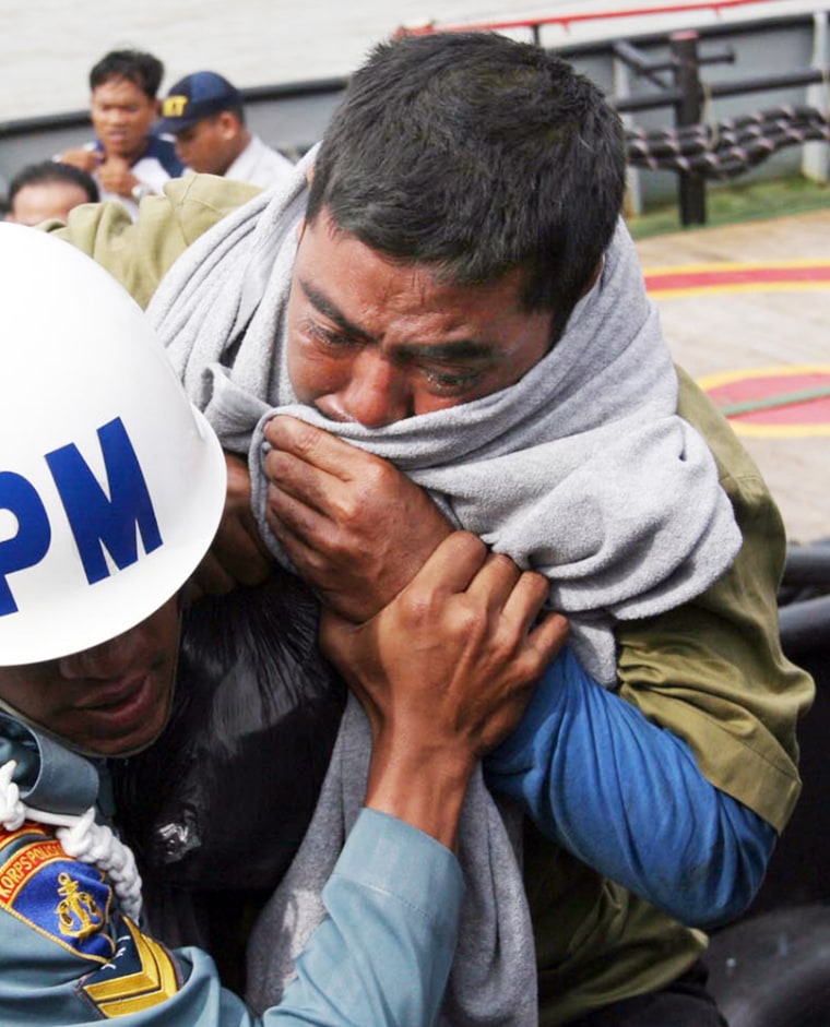 A survivor of last week's ferry accident weeps Wednesday as he is carried by Indonesian navy personnel upon arrival at a port in Surabaya, Indonesia. 